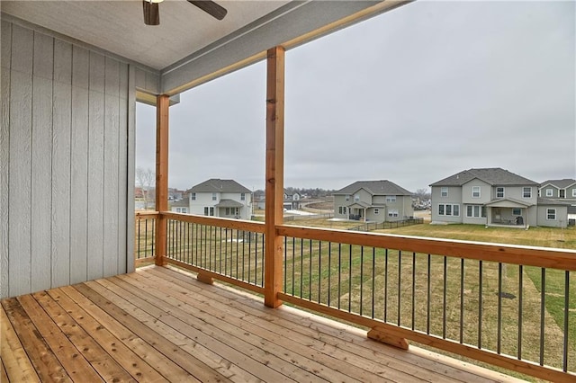 wooden deck with a residential view, a yard, and ceiling fan