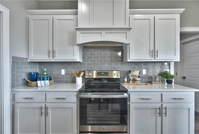 kitchen featuring white cabinetry, light countertops, backsplash, and stainless steel electric stove