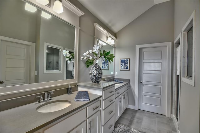 bathroom with lofted ceiling, double vanity, tile patterned flooring, and a sink