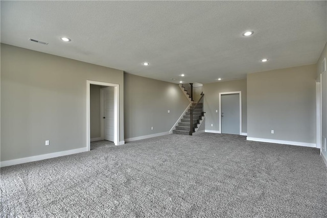 carpeted spare room with recessed lighting, visible vents, a textured ceiling, baseboards, and stairs