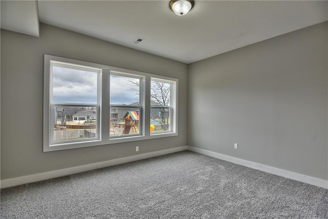 spare room featuring carpet flooring and baseboards