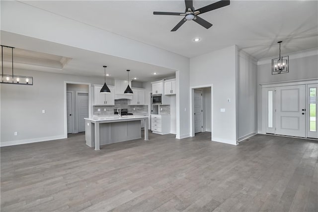 2850 W Wabash St, Olathe, KS 66061 - kitchen featuring baseboards, stainless steel microwave, open floor plan, recessed lighting, and crown molding