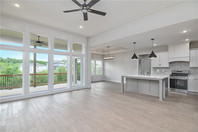 2850 W Wabash St, Olathe, KS 66061 - kitchen featuring stainless steel range, a ceiling fan, baseboards, open floor plan, and tasteful backsplash