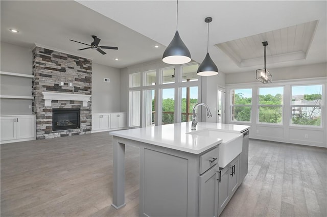 2850 W Wabash St, Olathe, KS 66061 - kitchen with a sink, light wood-style flooring, ceiling fan, light countertops, and a kitchen island with sink