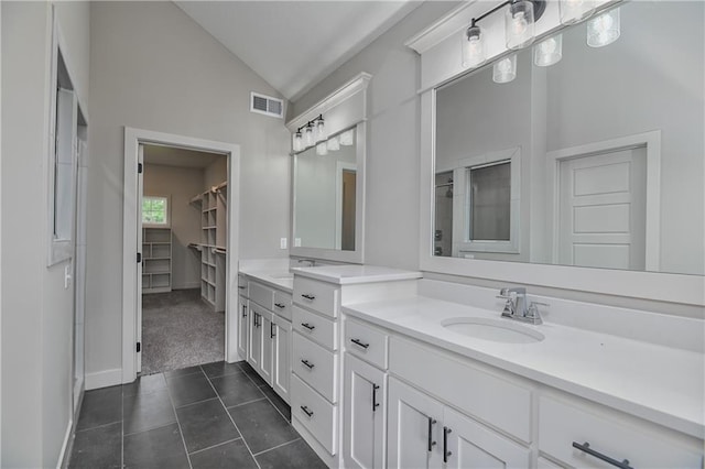2850 W Wabash St, Olathe, KS 66061 - bathroom featuring lofted ceiling, double vanity, a spacious closet, tile patterned flooring, and baseboards