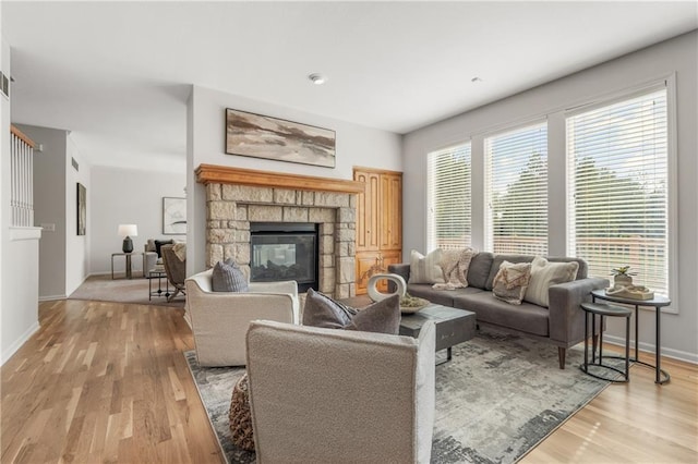 living area featuring baseboards, a fireplace, and light wood finished floors