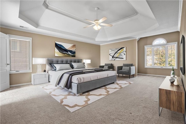 bedroom featuring baseboards, visible vents, a raised ceiling, and light colored carpet