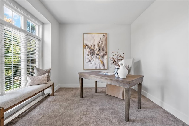 office space with baseboards and light colored carpet