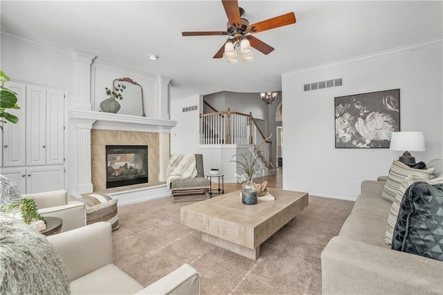 living room featuring light carpet, visible vents, crown molding, and stairway