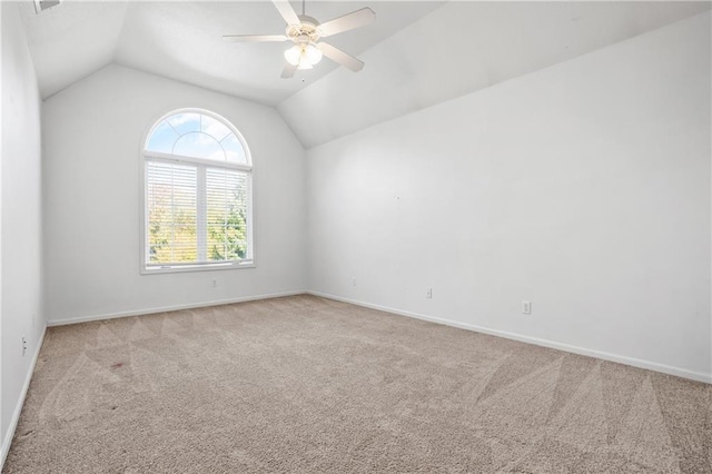 empty room featuring light carpet, ceiling fan, lofted ceiling, and baseboards