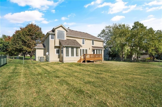 rear view of property with stucco siding, a fenced backyard, a lawn, and a wooden deck