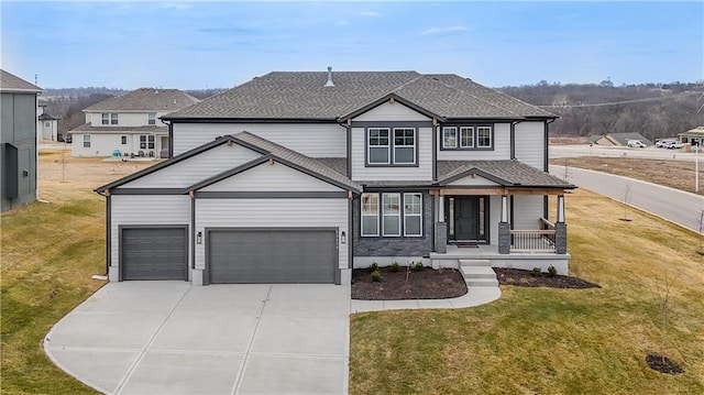 traditional-style house with a shingled roof, concrete driveway, an attached garage, a porch, and a front yard