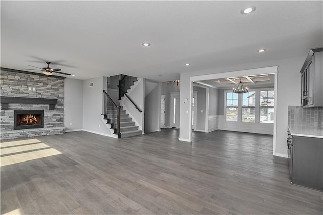 unfurnished living room featuring dark wood-style flooring, a fireplace, recessed lighting, stairway, and ceiling fan