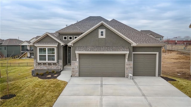 craftsman house with a shingled roof, fence, stone siding, stucco siding, and a front lawn