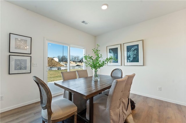 dining room featuring baseboards, visible vents, and light wood-type flooring