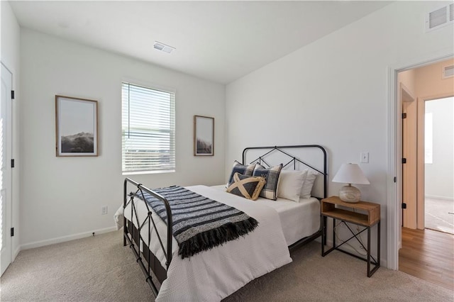 carpeted bedroom with baseboards and visible vents