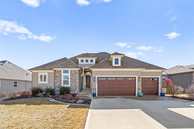 prairie-style home featuring a garage, driveway, stone siding, a front lawn, and stucco siding