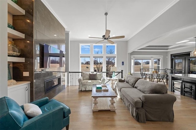 living room featuring a fireplace, crown molding, and wood finished floors