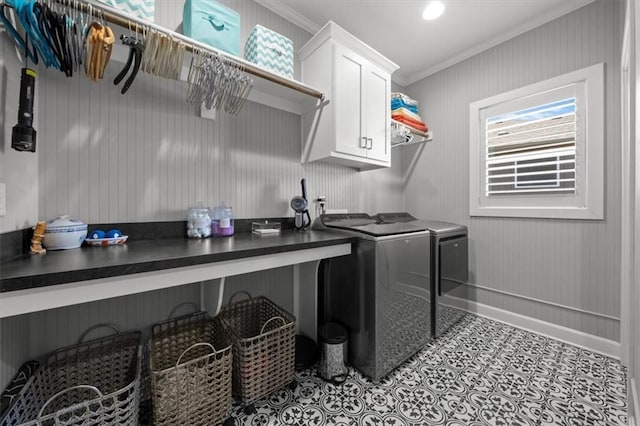 clothes washing area featuring baseboards, cabinet space, crown molding, and washing machine and clothes dryer