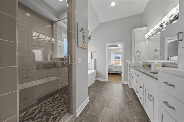 bathroom featuring baseboards, a soaking tub, ensuite bathroom, vanity, and a shower stall