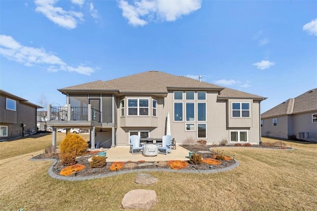 rear view of house with a patio, a yard, central AC, and a sunroom