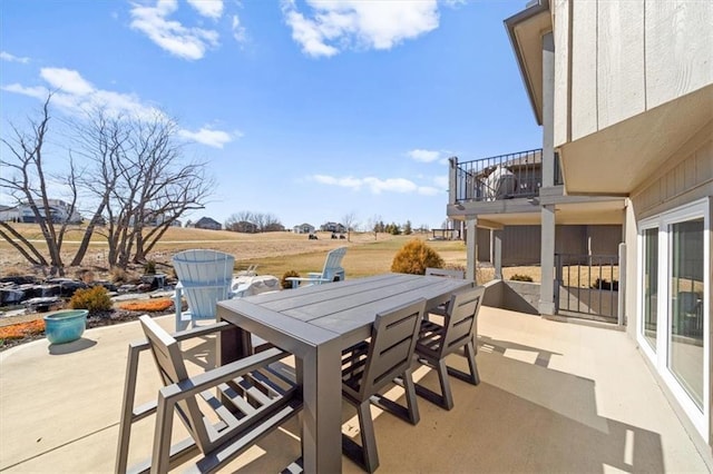 view of patio featuring outdoor dining area and a balcony