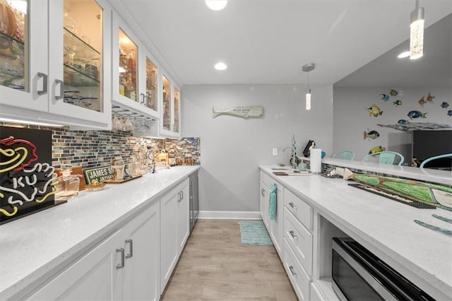 14423 N 145th St, Basehor, KS 66007 - bar with hanging light fixtures, tasteful backsplash, baseboards, recessed lighting, and light wood-style flooring