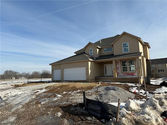 view of front of house featuring an attached garage and roof with shingles