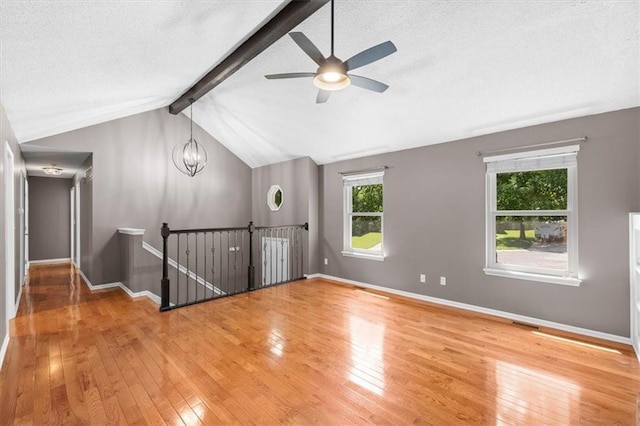 bonus room featuring a textured ceiling, lofted ceiling with beams, baseboards, and wood finished floors