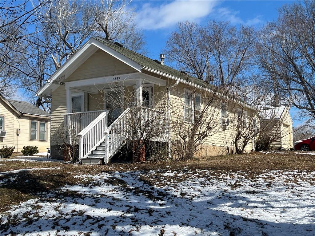 bungalow-style house featuring covered porch and stairs