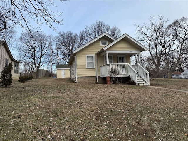 bungalow with a porch and an outbuilding