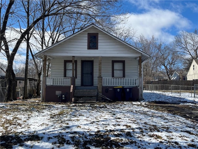 view of front of home with covered porch and fence