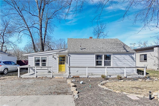 view of front of property with roof with shingles and a chimney