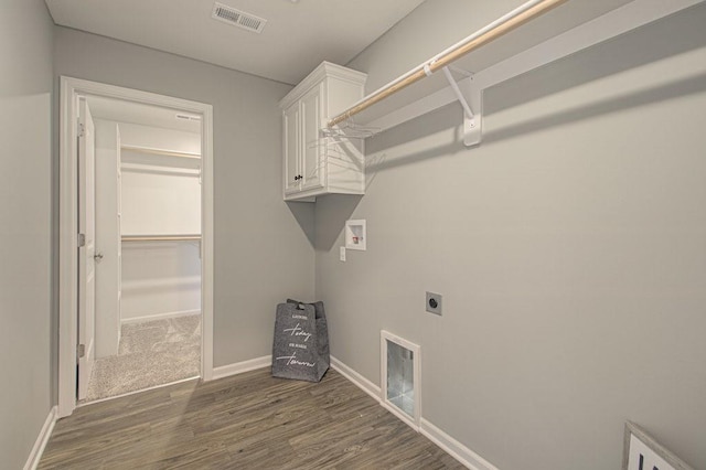 clothes washing area with hookup for a washing machine, visible vents, electric dryer hookup, and dark wood-style floors