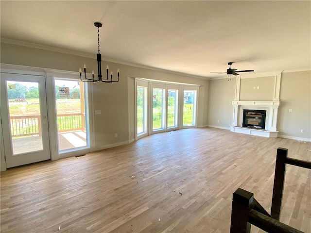 9100 NE 98th Ter, Kansas City, MO 64157 - unfurnished living room with crown molding, light wood-style flooring, a chandelier, ceiling fan, and a glass covered fireplace