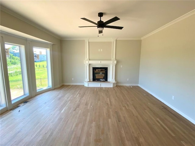 9100 NE 98th Ter, Kansas City, MO 64157 - unfurnished living room featuring wood finished floors, a ceiling fan, a fireplace with raised hearth, and ornamental molding