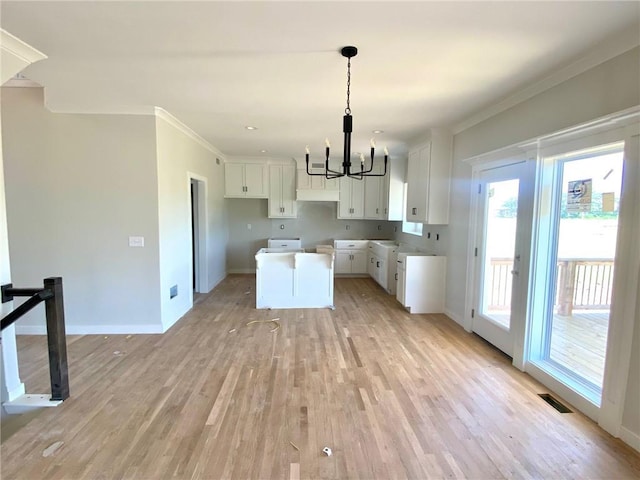 9100 NE 98th Ter, Kansas City, MO 64157 - kitchen with a chandelier, light wood finished floors, ornamental molding, white cabinets, and a kitchen island