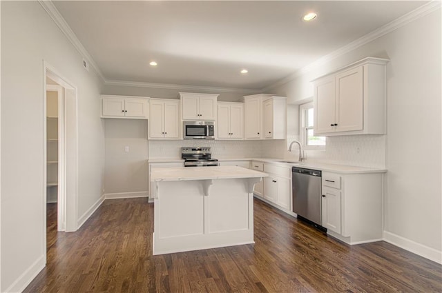 9100 NE 98th Ter, Kansas City, MO 64157 - kitchen featuring appliances with stainless steel finishes, a center island, white cabinets, ornamental molding, and recessed lighting