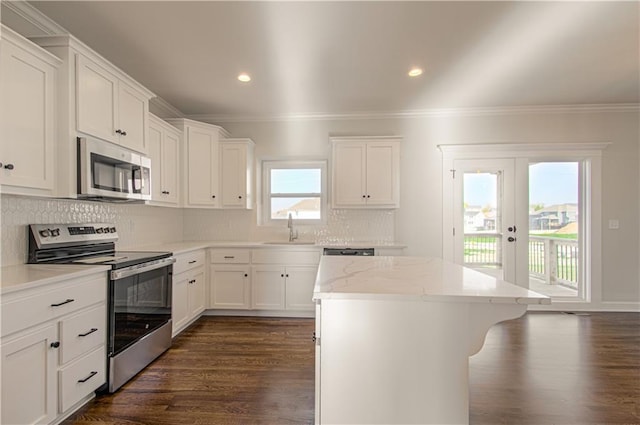 9100 NE 98th Ter, Kansas City, MO 64157 - kitchen featuring stainless steel appliances, ornamental molding, a kitchen island, dark wood finished floors, and white cabinets