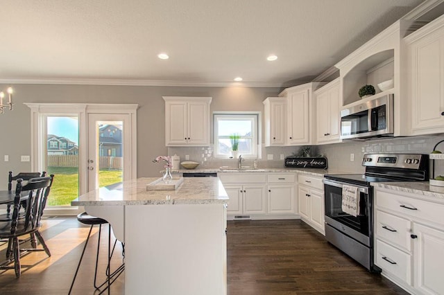 9100 NE 98th Ter, Kansas City, MO 64157 - kitchen featuring appliances with stainless steel finishes, open shelves, white cabinets, a center island, and backsplash