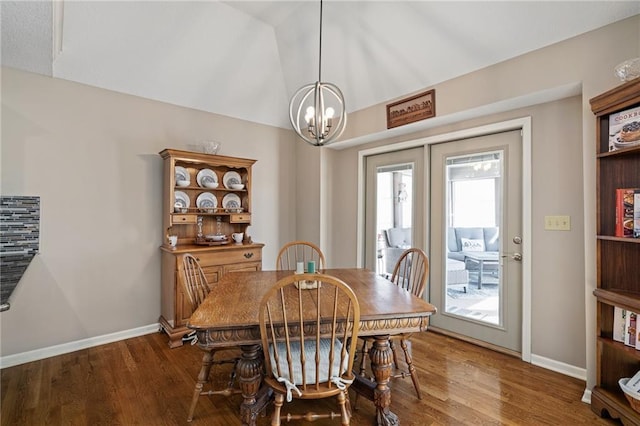 dining area featuring lofted ceiling, baseboards, and wood finished floors