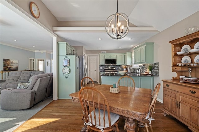 dining space featuring a chandelier, recessed lighting, crown molding, and wood finished floors