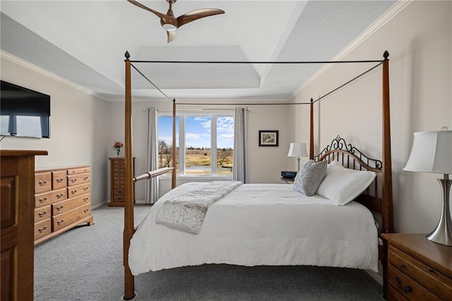 bedroom featuring ornamental molding, carpet, a raised ceiling, and a ceiling fan