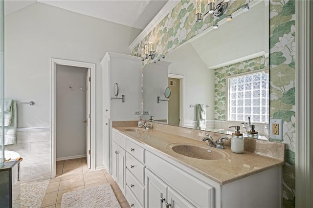 bathroom featuring double vanity, tile patterned flooring, vaulted ceiling, and a sink