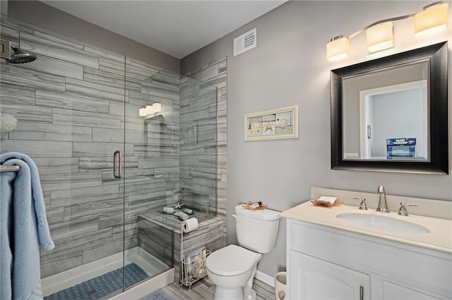 full bathroom with toilet, a stall shower, visible vents, and vanity