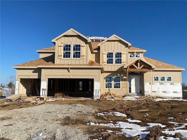 view of front of house with board and batten siding, gravel driveway, and an attached garage