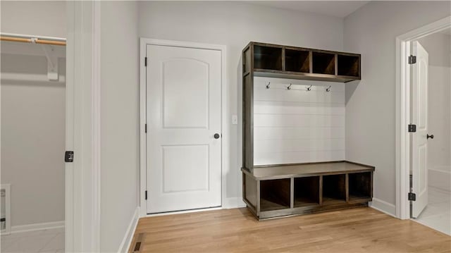 mudroom featuring light wood-type flooring, baseboards, and visible vents