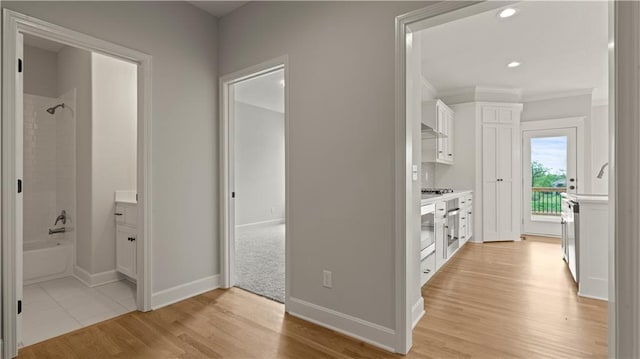 hallway with recessed lighting, light wood-type flooring, baseboards, and ornamental molding