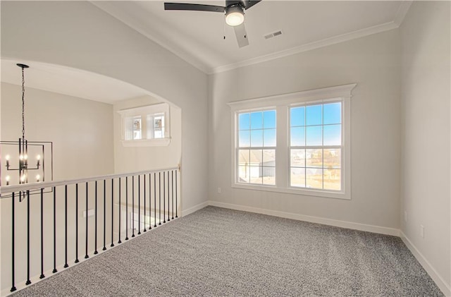 carpeted spare room featuring baseboards, plenty of natural light, ornamental molding, and ceiling fan with notable chandelier