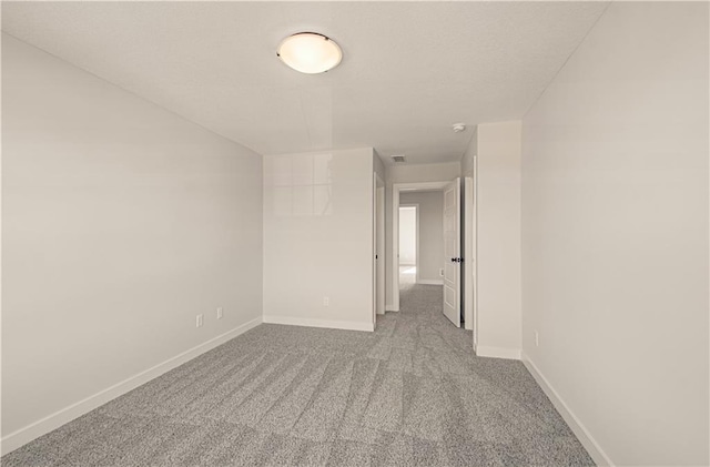 carpeted empty room with visible vents and baseboards